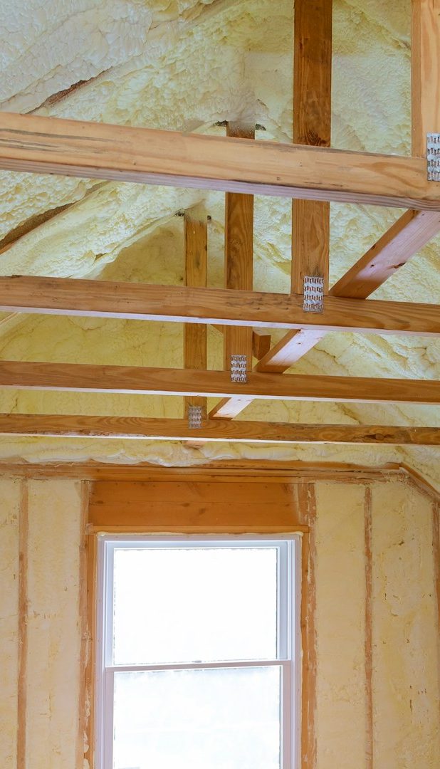 Wärmedämmung Holzrahmen und isolierte Decke in einem ungefertigten Raum mit einem Fenster.