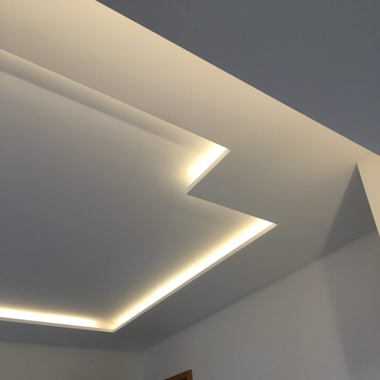 Trockenbau Decke mit modernem Lichtdesign und geometrischen Formen in neutralen Farbtönen.