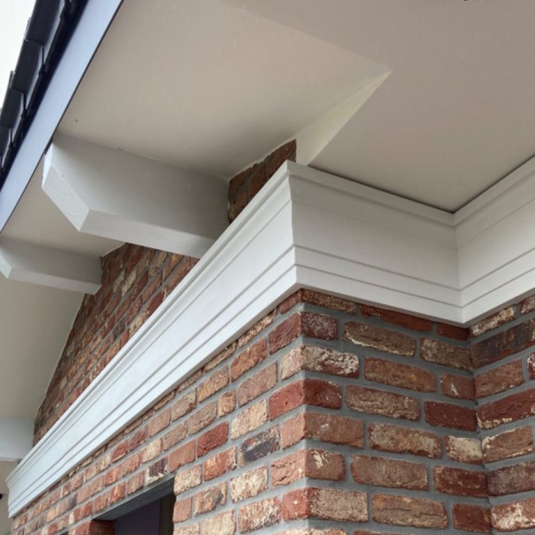 Stuck Fassade Eckdetail einer Fassade mit Ziegelsteinen und dekorativer Stuck-Verkleidung.